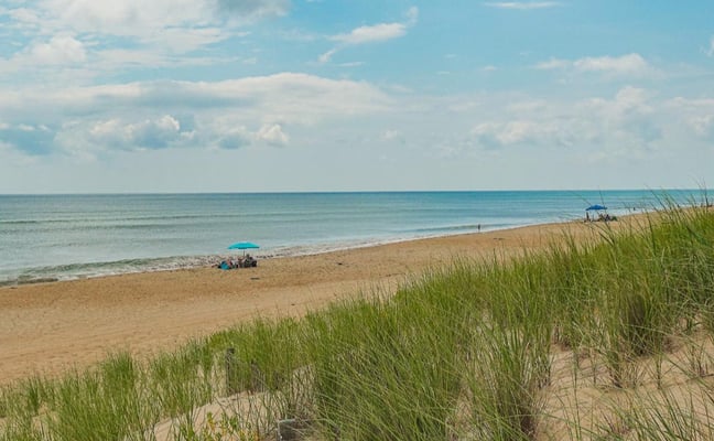 A beach scene with an umbrella looking at the ocean in Southern Shores.